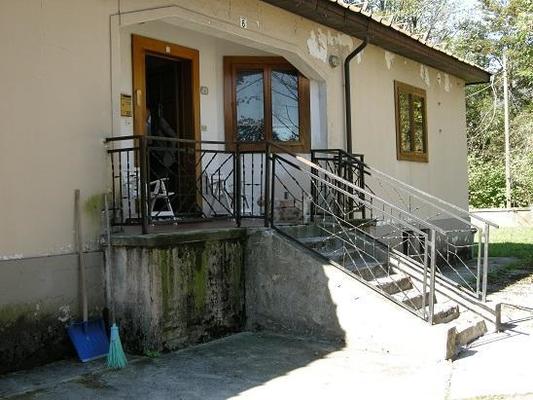 Descrizione: Ingresso, soggiorno, cucina, 2 camere, bagno e ripostiglio. pertinenziale box auto, n. 4 cantine al piano seminterrato, deposito sottotetto, corte esterna sup. cat. Alloggio: 129 mq (comprensiva di quota parte di cantine al piano seminterrato, deposito sottotetto ed area esterna esclusiva) . Identificativi catastali: foglio 5, part. 1309, sub. 8 (incluso n. 4 cantine al piano seminterrato, deposito sottotetto e corte esterna ad uso esclusivo), con box auto al foglio 5, part. 1309, sub. 13
