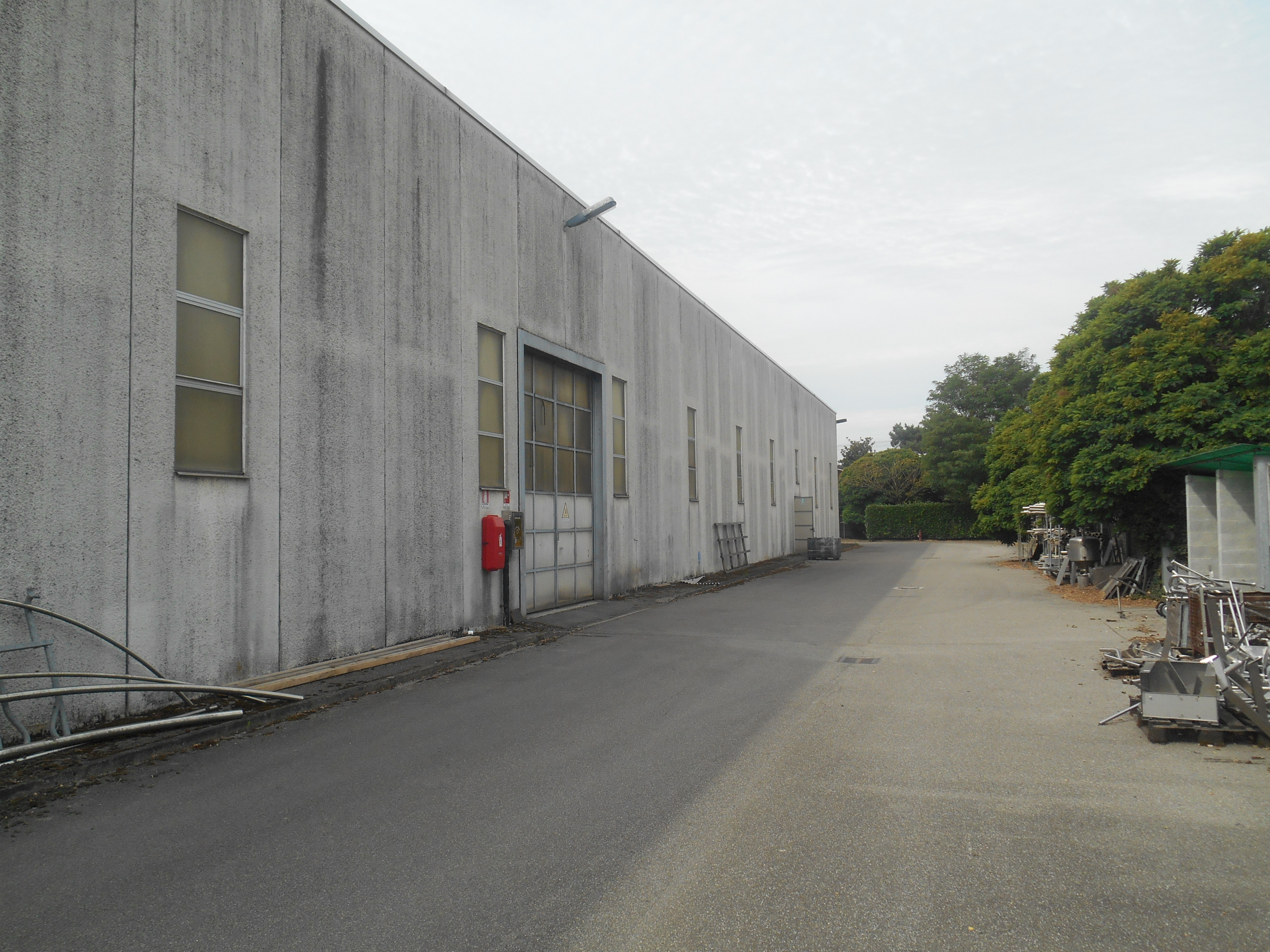 Capannone industriale con annessi uffici e servizi e area cortiliza. Presenza di ulteriori unità immobiliari adiacenti al capannone demaniale di proprietà di terzi. Identificativi catastali: comune di Zelo Buon Persico C.F. foglio 1 particella 185 sub. 702 graffato al mapp. 453 e particella 185 sub. 704 graffato al mapp. 454 - In corso aggiornamenti catastali