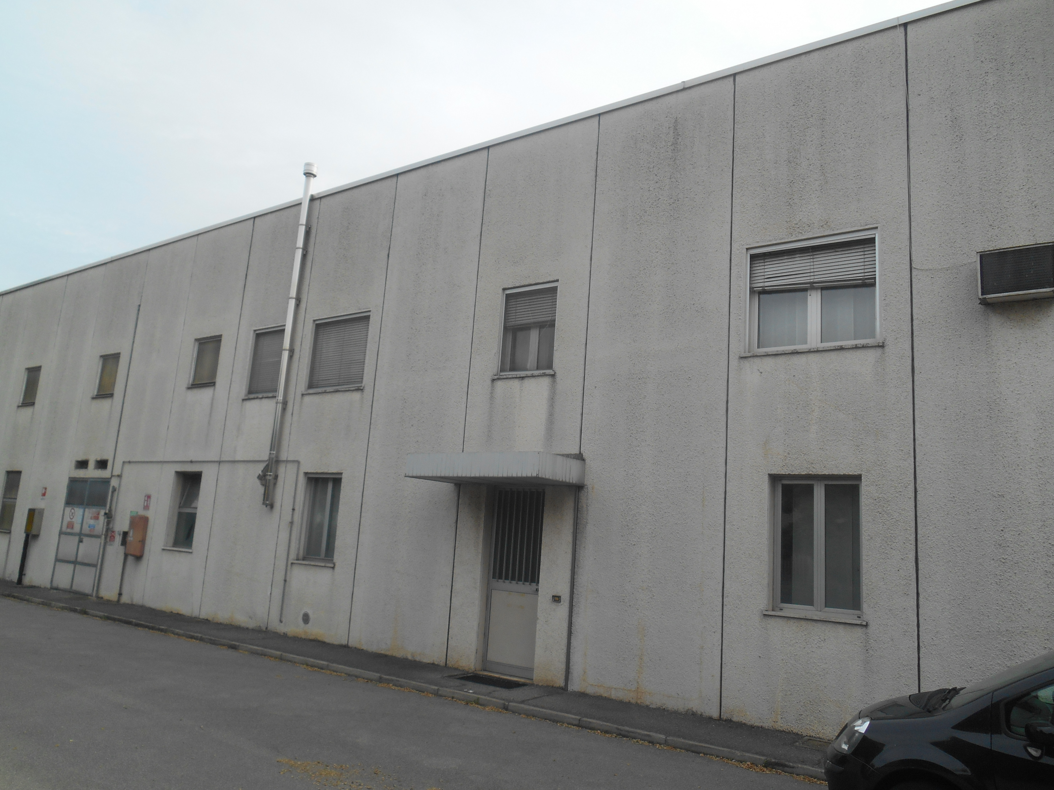Capannone industriale con annessi uffici e servizi e area cortiliza. Presenza di ulteriori unità immobiliari adiacenti al capannone demaniale di proprietà di terzi. Identificativi catastali: comune di Zelo Buon Persico C.F. foglio 1 particella 185 sub. 702 graffato al mapp. 453 e particella 185 sub. 704 graffato al mapp. 454 - In corso aggiornamenti catastali