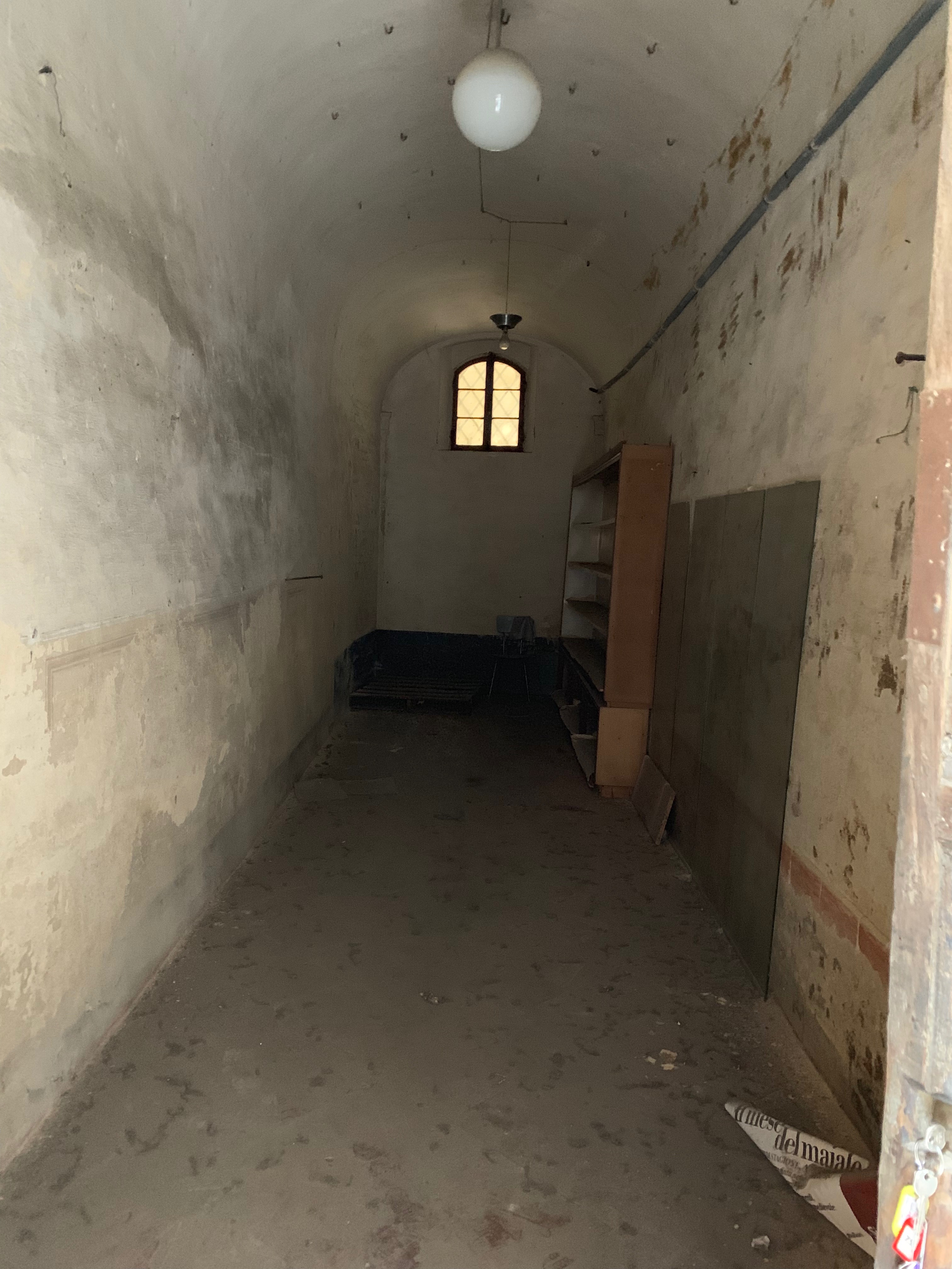 Unità immobiliare a destinazione commerciale situata al piano terra di un edificio di carattere storico-artistico denominato “Palazzo Piccolomini”. La parte più antica, di cui fa parte l'unità immobiliare in esame, è stata costruita su progetto del Rossellino ed era anticamente la dimora della celebre famiglia senese dei Piccolomini. Il fondo commerciale risulta composto da un unico ambiente con forma planimetrica rettangolare, stretta ed allungata, areata da una finestra posizionata sul lato opposto rispetto all’ingresso da via del Porrione. Identificativi catastali: C.F. Comune di Siena foglio 134, particella 13, subalterno 12.