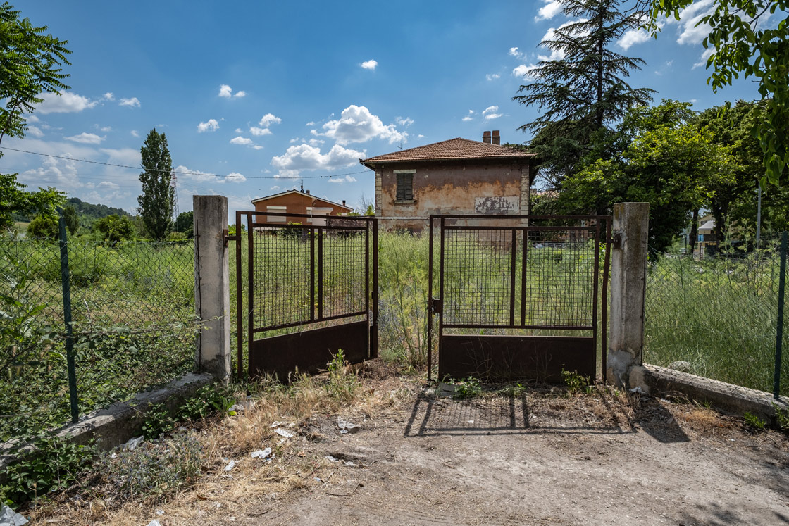 Compendio costituito da un fabbricato diviso in 2 unità immobiliari destinate ad abitazione, con annessi garages, stalletto e relativa area pertinenziale recintata. La costruzione risale agli anni ’30 del secolo scorso e presenta le caratteristiche tipologiche della casa cantoniera bifamiliare. Il complesso presenta potenzialità edificatoria residua, compatibile con il vincolo d’interesse culturale a cui è soggetto. Identificativi catastali: CT del comune di Foligno Fg 106 part. 1925 e CF del comune di Foligno Fg 106 part. 1925 subb 4, 5, 6, 7 e, 8 (graffato con sub 5).