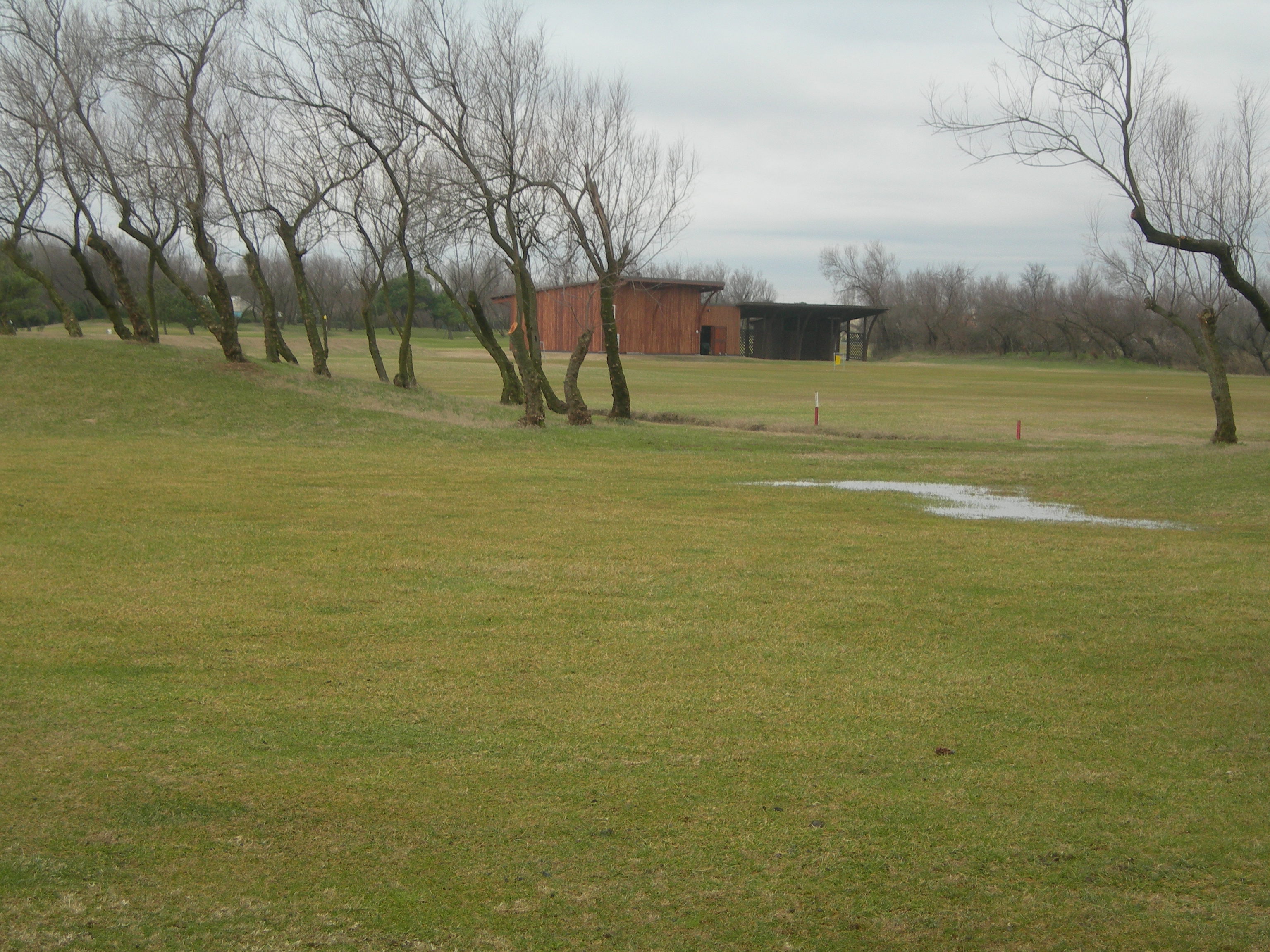 Area costituente la maggior porzione di più ampio campo da golf, sulla quale insistono un fabbricato di un piano f.t. adibito a magazzino e un manufatto in legno con tettoia. Identificativi catastali: CT fg. 29 mapp. 1634,6645,6647 - CF fg. 29 mapp. 3237.