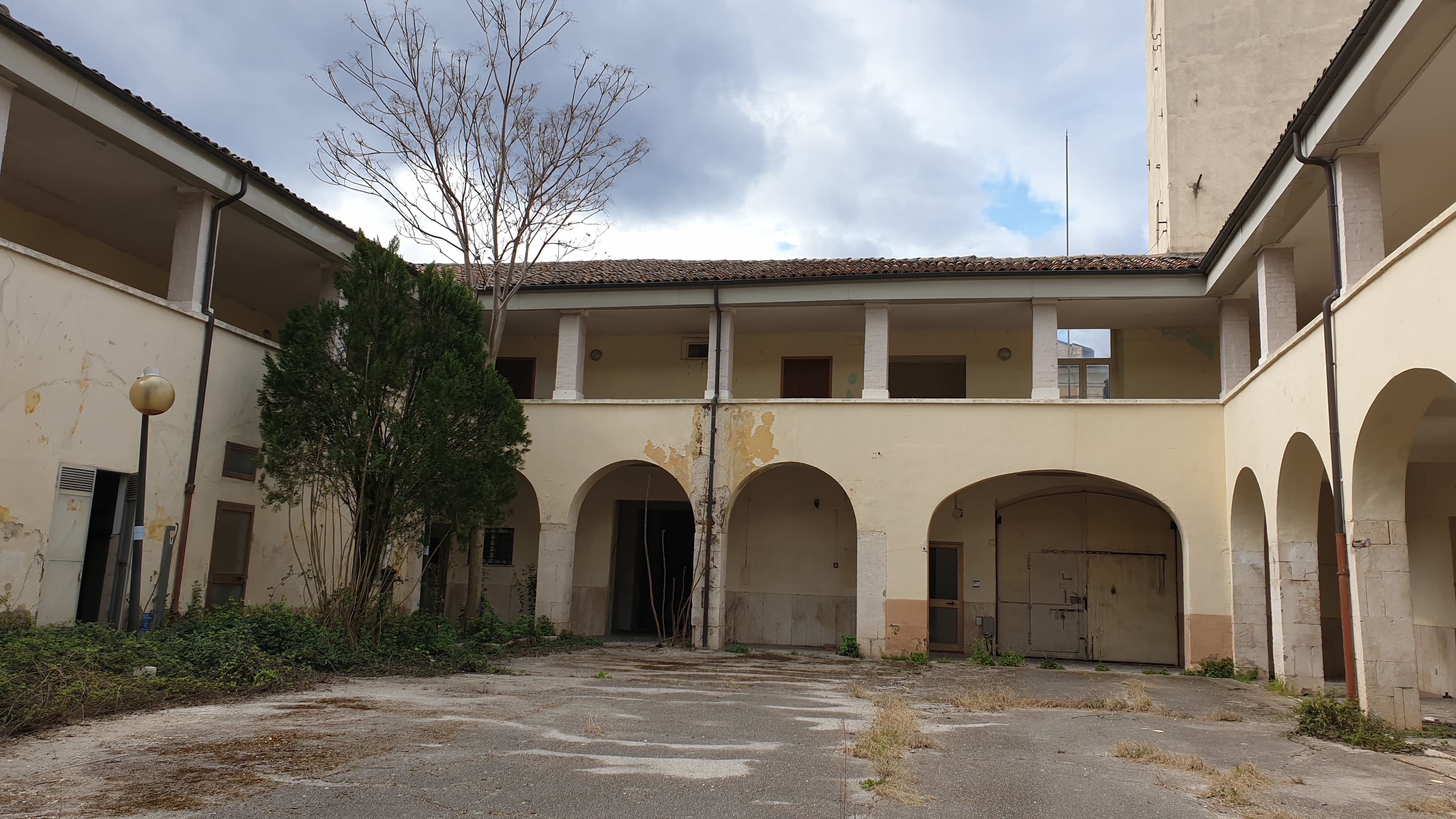 Ex convento medioevale, successivamente adibito a caserma. La struttura si compone di due piani. Al piano terra sono presenti la cucina, i relativi magazzini e la sala mensa. Inoltre sono presenti uffici, vari locali tecnologici, il corpo di guardia e un locale bar. Il piano primo presenta due appartamenti, la foresteria, varie camere ed una serie di uffici. Servizi igienici Completano il piano. Le connessioni tra i due livelli sono assicurati da tre corpi scala, due interni ed uno esterno.. Identificativi catastali: C.T. foglio 60 p.lla 2141
C. F. foglio 60 p.lla 2141