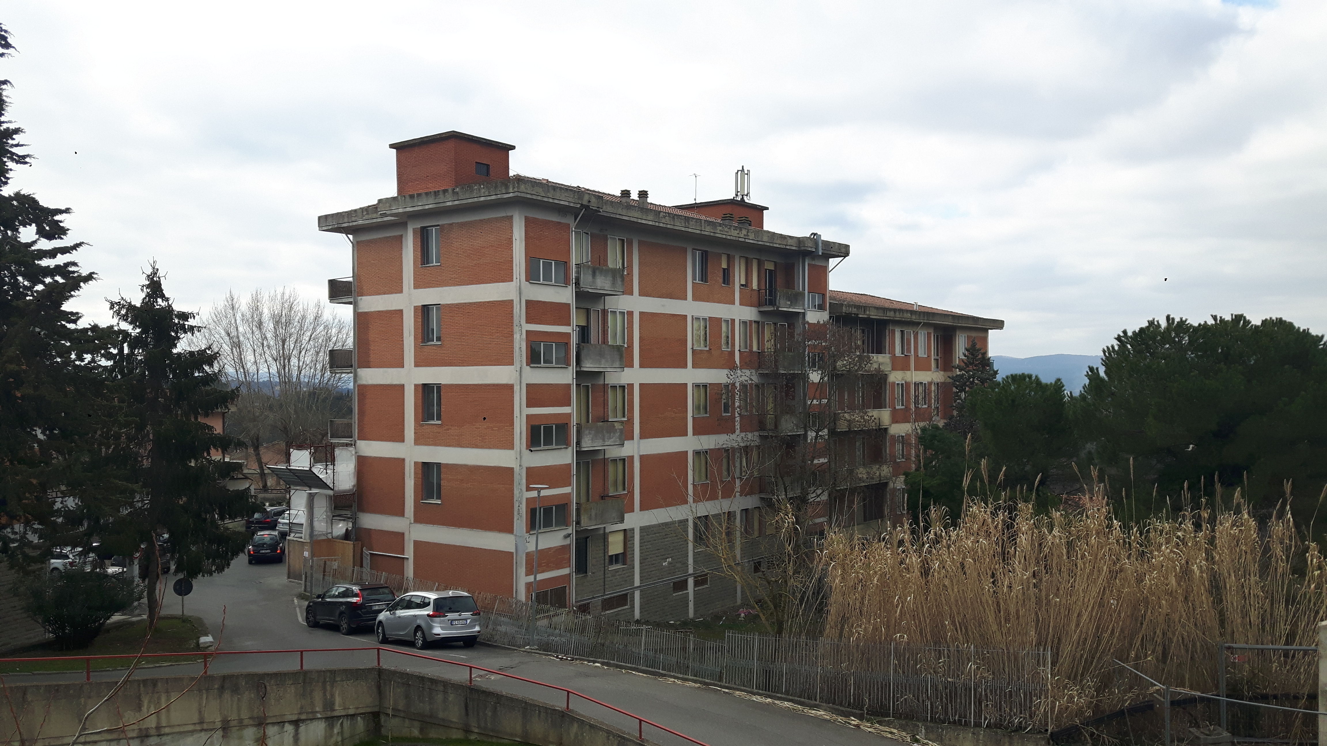 trattasi di un complesso immobiliare ubicato nel comune di Siena, in piazza Calabria, nel quartiere residenziale denominato Vico Alto.
L’immobile si presenta come un fabbricato cielo – terra, con pianta ad “L” che si eleva per sei piani fuori terra, distinto in due corpi di fabbrica adiacenti tra di loro con quote sfalsate. Completa la proprietà un resede esterno in parte adibito a verde ed in parte a parcheggio. 
L’immobile versa in pessimo stato di manutenzione, con evidenti problemi strutturali tali da ipotizzare l’impossibilità del riuso dello stesso senza la sua completa demolizione e ricostruzione.
. Identificativi catastali: C.F. del Comune di Siena Foglio 13, particella 673, subalterni 4, 5, 6