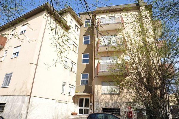 Descrizione: Ingresso, soggiorno, disimpegno, camera, cucina, bagno, balcone e terrazzo + pertinenziale cantina, deposito ad uso comune (proprietà 90,909 millesimi), autorimessa ad uso comune (proprietà 90,909 millesimi), posti auto scoperti ad uso comune (proprietà millesimi 90,909) e box auto ad uso comune (proprietà millesimi 90,909). Mq. 97. N.C.E.U. A3 foglio 83 part. 2338 sub. 21, con cantina al foglio 83 part. 2338 sub. 8, deposito ad uso comune al foglio 83 part. 2338 sub. 26 (millesimi 90,909), autorimessa ad uso comune al foglio 83 part. 2338 sub. 27 (millesimi 90,909), posto auto scoperto ad uso comune al foglio 83 part. 2338 sub. da 28 a 36 (millesimi 90,909) e box auto ad uso comune al foglio 83 part. 2340 sub. da 1 a 4 (millesimi 90,909)