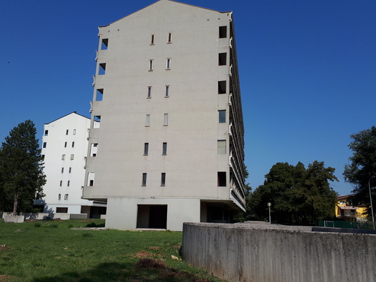 Palazzina alloggi costituita da un unico corpo di fabbrica ad uso residenziale alla quale si accede da due distinti corpi scala. Il fabbricato, con pianta rettangolare, si sviluppa su 7 piani fuori terra che ospitano 31 unità abitative, unitamente ad un piano pilotis adibito a porticato e spazi di manovra. Il piano seminterrato è adibito ad autorimessa e cantine.Il complesso alloggiativo è dotato di un'ampia corte esterna (giardino, camminamenti). Risultano di pertinenza 31 autorimesse, 31 cantine, ampia corte esterna adibita a giardino. Identificativi catastali Foglio 65, Part.1653.+