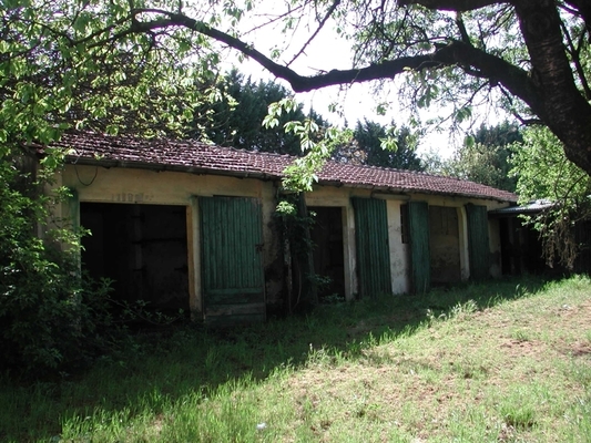 Complesso alloggiativo costituito da due corpi di fabbrica, uno dei quali adibito a residenziale e l'altro a box auto e locali deposito. L'edificio residenziale, a base quadrata, si sviluppa su 2 piani fuori terra che ospitano 2 unità abitative, unitamente ad un piano interrato adibito a cantine (n. 2 locali cantina). Il secondo corpo di fabbrica, a base rettangolare, si sviluppa su un unico piano fuori terra ed è costituito da numero 3 box auto e numero 2 locali deposito. L'intero complesso alloggiativo è dotato di una vasta area esterna di pertinenza esclusiva completamente recintata. Risultano di pertinenza 4 locali deposito, 3 box auto. Identificativi catastali Foglio 20, Part.162.