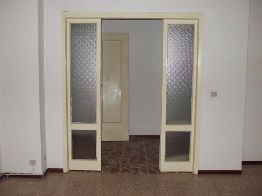 Immobile composto da ingresso, soggiorno, corridoio, 2 bagni, cucina, ripostiglio, 2 camere, balcone e box auto, cantina, n.2 depositi ad uso comune (mill.157,45). Identificativi Catastali [N.C.E.U.] cat. A3 foglio 42 part. 422 sub. 1 (incluso cantina), con box auto ad uso esclusivo al foglio 42 part. 422 sub. 12, deposito ad uso comune (millesimi di proprietà 157,45) al foglio 42 part. 422 sub. 30 e deposito ad uso comune (millesimi di proprietà 157,45) al foglio 42 part. 422 sub. 31