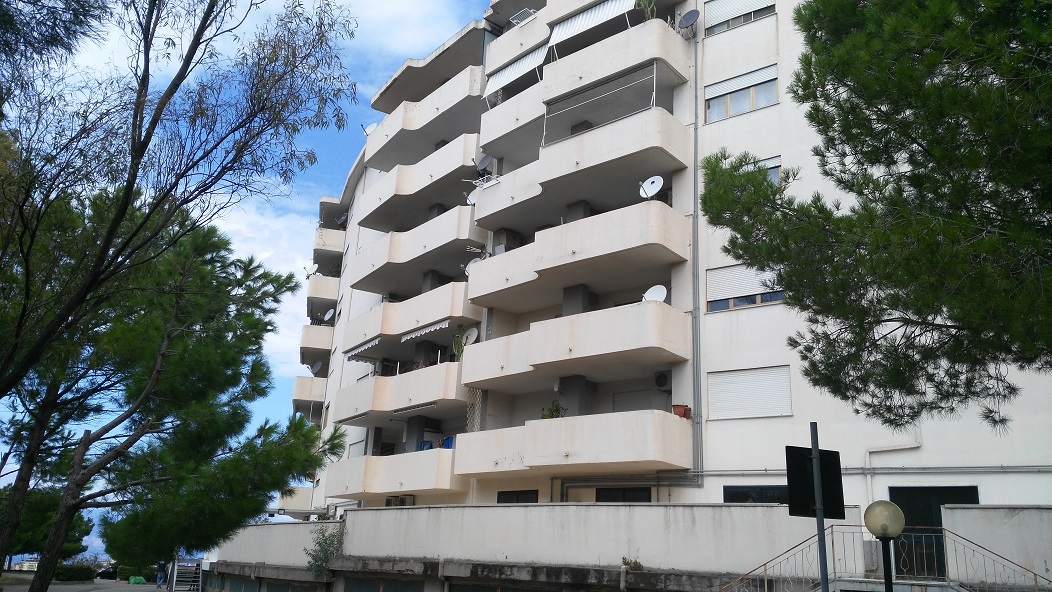 ingresso, corridoio, soggiorno, tre camere, cucina e due bagni, di cui uno con areazione meccanica. Sono presenti due balconi. Cantina piano seminterrato + posto auto esclusivo al piano seminterrato. Identificativi Catastali - [N.C.E.U.] Unità Residenziale cat. A/2 Sez. GNA foglio 5 part. 475 sub 89  - Unità Secondaria cat. C/6 Sez. GNA foglio 5 part. 475 sub 209