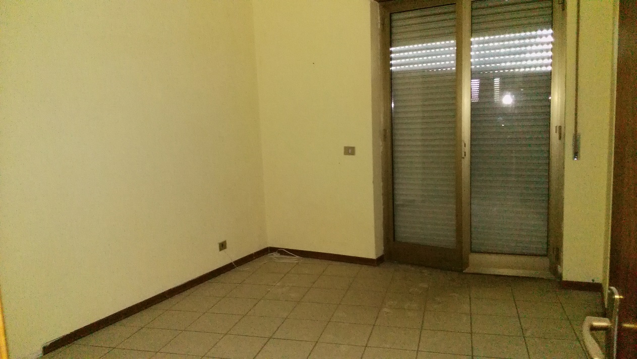 ingresso, corridoio, soggiorno, tre camere, cucina e due bagni, di cui uno con areazione meccanica. Sono presenti due balconi. Cantina piano seminterrato + posto auto esclusivo al piano seminterrato. Identificativi Catastali - [N.C.E.U.] Unità Residenziale cat. A/2 Sez. GNA foglio 5 part. 475 sub 89  - Unità Secondaria cat. C/6 Sez. GNA foglio 5 part. 475 sub 209