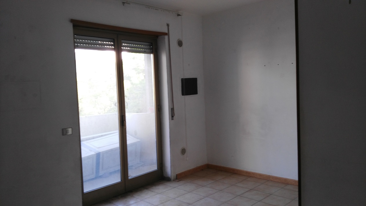 ingresso, corridoio, soggiorno, tre camere, cucina e due bagni, di cui uno con areazione meccanica. Sono presenti due balconi. Cantina piano seminterrato + posto auto esclusivo al piano seminterrato. Identificativi Catastali - [N.C.E.U.] Unità Residenziale cat. A/2 Sez. GNA foglio 5 part. 475 sub 89  - Unità Secondaria cat. C/6 Sez. GNA foglio 5 part. 475 sub 209