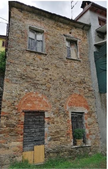 Una unità immobiliare ad uso magazzino posta all’interno di un vecchio edificio e che ne costituisce l’intera consistenza, ubicata al limite sud di Pariana. Il fabbricato è costituito da una vecchia struttura in muratura ordinaria a base rettangolare con il lato maggiore che si affaccia sulla Via Comunale. Su un piano fuori terra ed uno seminterrato, con tetto a due falde, si trova in stato di abbandono e risultano essere necessari radicali lavori di ristrutturazione per renderlo nuovamente agibile.