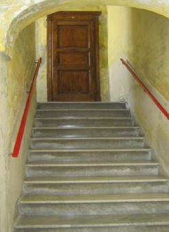 L’unità immobiliare, con destinazione residenziale, è ubicata al piano primo di un vecchio fabbricato denominato “Palazzo Gobbi”, si compone di tre camere, sala centrale di disimpegno ai vari locali, bagno, cucina, veranda di disimpegno chiusa con vetri ed altro piccolo disimpegno, oltre a locale cantina posto al piano interrato del fabbricato.