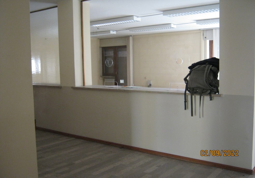 L'ufficio occupa l'intero piano primo della palazzina residenziale. Diversi locali uso ufficio e un ampio ambiente, delimitato lungo il corridoio da una parete vetrata costruita a bancone al fine di delimitare un'area front office. L'ufficio che presenta affacci su quattro lati del fabbricato, dispone di tre balconi di cui due sulla facciata principale lungo via Feltre. Sono presenti due distinti servizi igienici, , nonchè un ampio corridoio di collegamento, che serviva anche da zona d'attesa per l'utenza. All'ufficio si arriva dalla scala principale e dall’ascensore presente nell’androne dello stabile. Anche una piccola cantina al piano seminterrato. Identificativi Catastali [N.C.E.U.] Unità Principale cat. B/4 foglio 84 part. 49 sub 9. SUP. MQ(ARR.)catastali 243. Piena Proprietà. Libero.