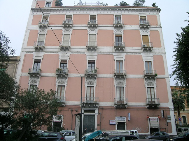 Immobile destinato ad uffici, parte di fabbricato di sei piani, con struttura verticale in muratura portante e copertura a terrazzo. Facciate con intonaco e decorate con cornici e fregi in pietra e gesso, gli infissi e il portone d’ingresso sono in legno. I fronti prospicienti Piazza Giovanni Verga, con piano terra costituito da attività commerciali e quattro piani con destinazioni prevalenti uffici oltre il piano attico. Le unità immobiliari sono al quarto piano, collegate tra di loro da un’apertura interna. L’immobile esternamente in buono stato, all’interno in condizioni mediocri. In corso gli adempimenti per l’accertamento presso la Soprintendenza ai BB.CC.AA. di Catania della verifica di dichiarazione di interesse culturale (V.I.C.). Sup. Mq (Arr) 302. Lotto Libero, Piena Proprietà.