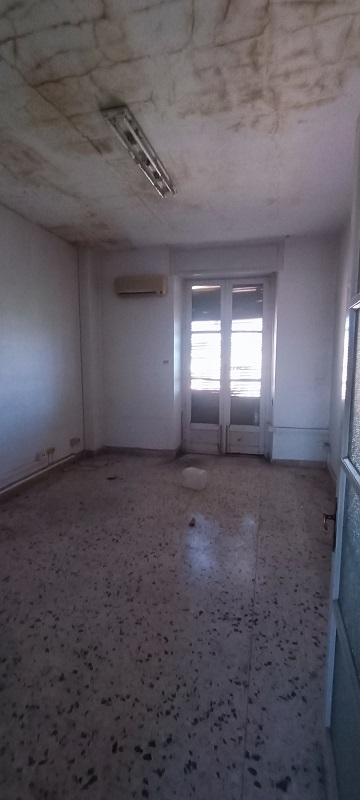 Immobile destinato ad uffici, parte di fabbricato di sei piani, con struttura verticale in muratura portante e copertura a terrazzo. Facciate con intonaco e decorate con cornici e fregi in pietra e gesso, gli infissi e il portone d’ingresso sono in legno. I fronti prospicienti Piazza Giovanni Verga, con piano terra costituito da attività commerciali e quattro piani con destinazioni prevalenti uffici oltre il piano attico. Le unità immobiliari sono al quarto piano, collegate tra di loro da un’apertura interna. L’immobile esternamente in buono stato, all’interno in condizioni mediocri. In corso gli adempimenti per l’accertamento presso la Soprintendenza ai BB.CC.AA. di Catania della verifica di dichiarazione di interesse culturale (V.I.C.). Sup. Mq (Arr) 302. Lotto Libero, Piena Proprietà.