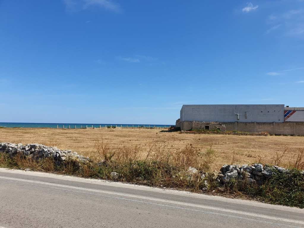 Il terreno, di natura agricola è ubicato in zona caratterizzata da terreni la cui destinazione ordinaria è quella seminativi, sul lato mare SS 16, e di uliveto verso l'interno. A confine con i terreni in esame vi sono capannoni artigianali, mentre a poche centinaia di metri è ubicato un complesso residenziale destinato a villini. I suoli. censiti al catasto terreni con la qualità seminativo, sono attualmente incolti; nel loro insieme hanno forma irregolare, assomigliante ad una L, e giacitura pianeggiante. I terreni sono cintati in parte da muro a secco. Dalla mappa catastale risulta rappresentata sulla particella 29 una costruzione di forma conica in pietra a secco, tipica delle zone rurali pugliesi, non più esistenti in loco