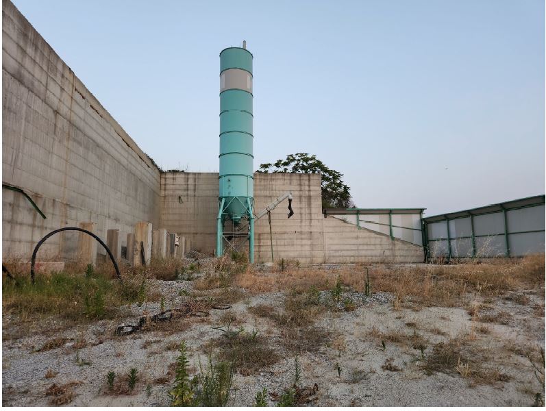 Terreno su cui insisteva impianto di betonaggio e su cui insistono dei manufatti abusivi insuscettibili di sanatoria, il prezzo a base d'asta è al netto dei costi di demolizione e smaltimento (stimati dal tecnico in € 30.000,00). L'aggiudicatario dovrà farsi carico delle seguenti attività per ciascun manufatto: demolizione / smontaggio dei manufatti; trasporto e conferimento in discarica autorizzata. Sup. mq (arr.) 8393. Immobile libero. Piena proprietà.