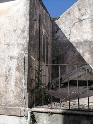 Fabbricato ant. al 1942, costituito da piccolo ingresso, due ampi vani comunicanti con un disimpegno da cui si accede al cortile esterno. Dal cortile si accede al servizio igienico e, tramite una scala, al piano primo terrazzo e un altro vano. Stato di degrado, costi di ripristino circa € 18.288,36. Censito in catasto come “sala giochi” con relativa agibilità. Un vano abusivo al primo piano delle seguenti dimensioni mq. 2,70 per 3,30. E’ ammessa la sola ristrutturazione edilizia con prospetto vincolato, caratterizzato da elementi pietra. Validità art. 48, comma 5 del D. Lgs. 159/2011. Un vano sito al primo piano al livello del terrazzo non rappresentato dalla planimetria catastale di 10,00 m2. Identificativi [N.C.E.U.] Fg. 17, part. 7271 (ex fg. 20, part. 238), cat. C/1   SUP. MQ (ARR.) 82