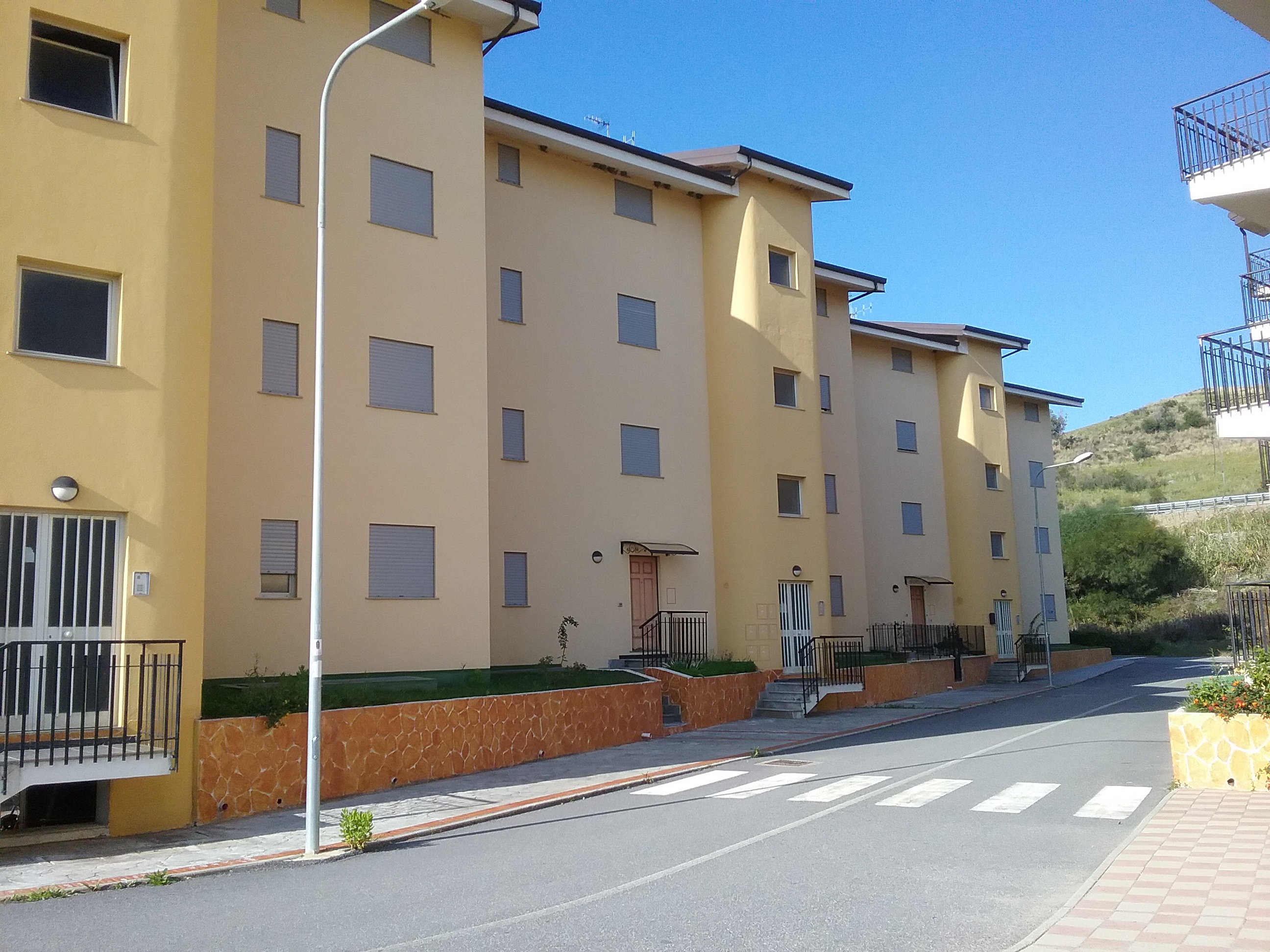 Alloggio facente parte di un complesso residenziale edificato in località Sperone Prato di Gizzeria. L'alloggio, si sviluppa su un unico livello a PT di un maggior fabbricato condominiale in c.a a più piani ft e si compone di una cucina soggiorno, due camere, bagno, balcone e corte esclusiva. Diritto di passaggio pedonale carrbile sulle aree esterne rimaste in proprietà alla società costruttrice CASE SUD con obbligo di partecipazione alle spese di manutenzione in forza delle quote millesimali allegate al regolamento di condominio esistente . ID. catastali Foglio 26, part 668, sub 25, categoria A3, classe 1 , vani 3,5 - Rendita catastale 117,49 . Sup. mq (arr.) 64