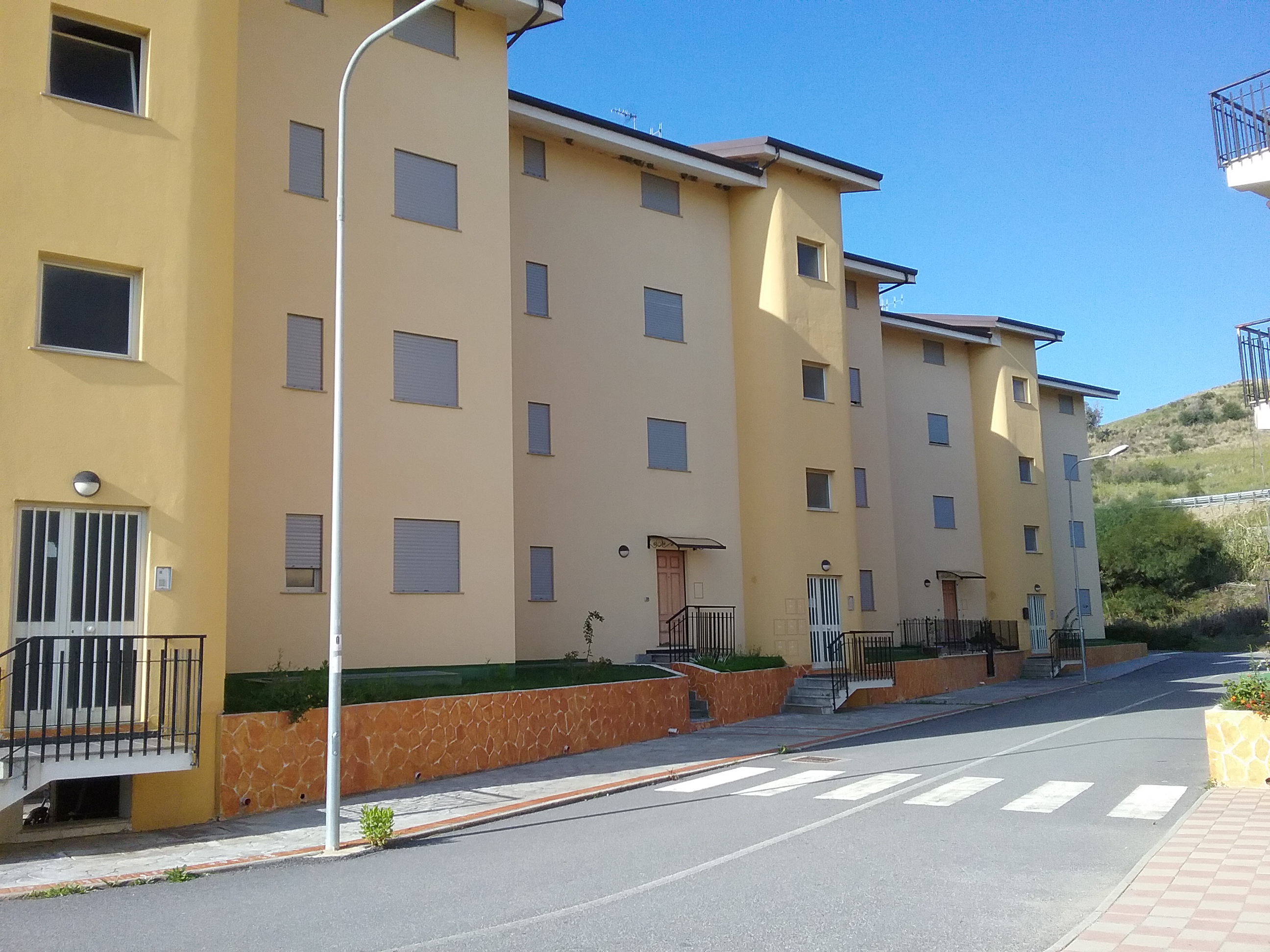 Alloggio facente parte di un complesso residenziale edificato in località Sperone Prato di Gizzeria. L'alloggio, si sviluppa su un unico livello a PT di un maggior fabbricato condominiale in c.a a più piani ft e si compone di una cucina soggiorno, due camere, bagno, balcone e corte esclusiva. Diritto di passaggio pedonale carrbile sulle aree esterne rimaste in proprietà alla società costruttrice CASE SUD con obbligo di partecipazione alle spese di manutenzione in forza delle quote millesimali allegate al regolamento di condominio esistente . ID. catastali Foglio 26, part 668, sub 25, categoria A3, classe 1 , vani 3,5 - Rendita catastale 117,49 . Sup. mq (arr.) 64