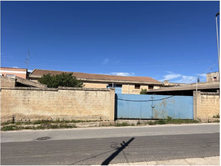 Magazzino di circa 400 m2. L’immobile occupa una superficie di circa 400 mq ed insiste su un appezzamento di terreno di circa 1210 mq;la struttura è realizzata in acciaio ed è tamponata con conci di tufo con finitura in malta di cemento, sabbia e grassello; il tetto è realizzato con architravi e traversi in legno che sorreggono una copertura in legno lamellare su cui a sua volta poggiano tegole in laterizio. La pavimentazione è realizzata in cemento battuto. Id. cat. [N.C.E.U.] foglio 64, particella 560 e 559. Sup. (arr) 400 mq + 800 mq piazzale