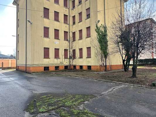 Il fabbricato, edificio isolato ad uso residenziale con pianta a “T”, è stato costruito negli anni '50 e presenta 4 piani fuori terra (destinato alle unità abitative) e un piano interrato (destinato alle cantine di pertinenza degli alloggi). Ogni piano è costituito da 3 unità abitative ad ognuna delle quali sono associate 2 pertinenze (una cantina e un box auto). Il complesso alloggiativo è dotato di una corte esterna comune completamente recintata nella quale sono collocati i 12 box auto pertinenziali. 12 cantine, 12 box auto, corte esterna ad uso comune. IDENTIFICATIVI CATASTALI [N.C.E.U.] Fg. 9 Part. 2218, cat. A3 - C6.