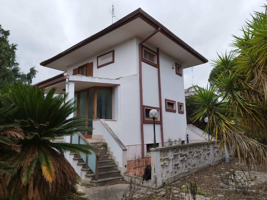 L'unità in stima composta da fabbricato adibito ad abitazione ai piani seminterrato, terra/rialzato e 1°, da fabbricato in muratura destinato a deposito e da struttura destinata a cucina esterna, entrambi al PT con accesso da giardino. Bene in stima si sviluppa su 3 liv. fuori terra ed uno entroterra. Dal raffronto stato dei luoghi con le planim. Lic. Edilizia n.897 (07/12/1973) e Ufficio, si rilevano variazioni di sagoma, installazione di 2 verande sui pianerottoli di accesso all'unità imm. a piano terra/rialzato, chiusura balcone a piano 1°, creazione e spostamento finestre, assenza della seconda scala interna, variazioni distribuzione interna come spostamenti di porte e tramezzi interni. ID catastali [N.C.E.U.] Cat. A/7 - Foglio 53 – Part.lla 402. Sup. mq 241,2. Libero. Proprietà 1/1.